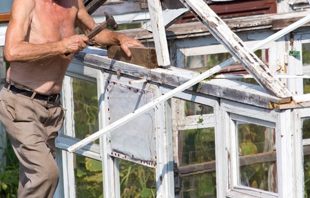The old man works with a greenhouse in the country .の写真素材