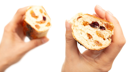 Buns with raisins in a hand on a white background .