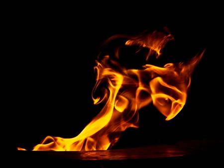 Red flame of fire on a black background .