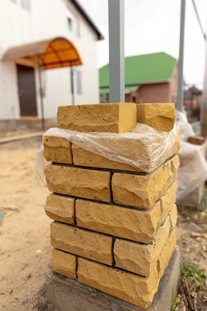 unfinished brick pillar at the construction site .