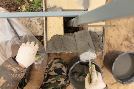 man builds a brick wall at a construction site .