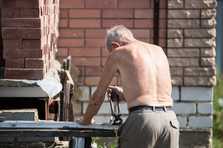 The old man works with a board in the country .の写真素材