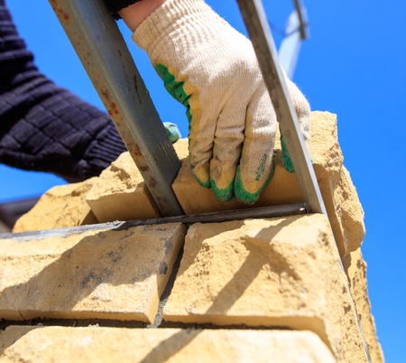 man builds a brick wall at a construction site .