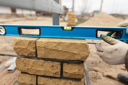 man builds a brick wall at a construction site .
