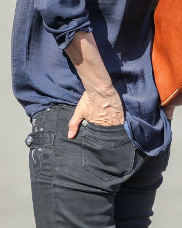Hand in the back pocket of jeans .