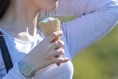 Girl with ice cream in hand in park .の写真素材