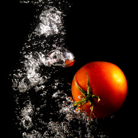 Red tomato in water on a black background .の写真素材