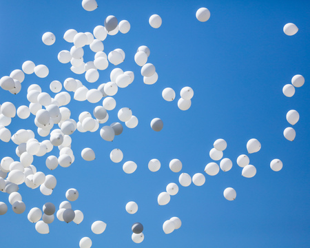 White balls flying in the blue sky .の写真素材