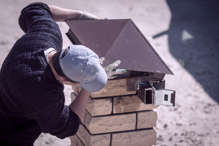 Worker builds brick posts near the gate of the house .の写真素材
