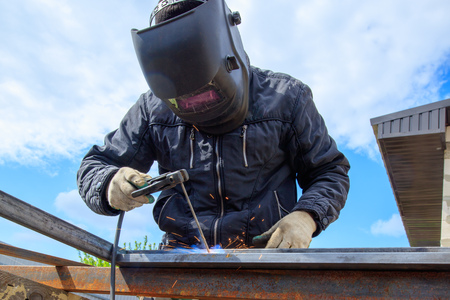 Welder welds metal at the construction site .