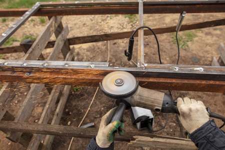 Worker cuts metal for doors at a construction site .