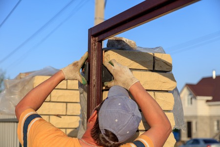 The worker installs rollers on the sliding gate .の写真素材