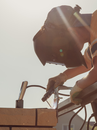 The worker installs rollers on the sliding gate .の写真素材