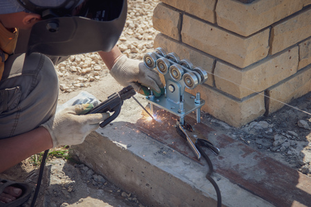 The worker installs rollers on the sliding gate .