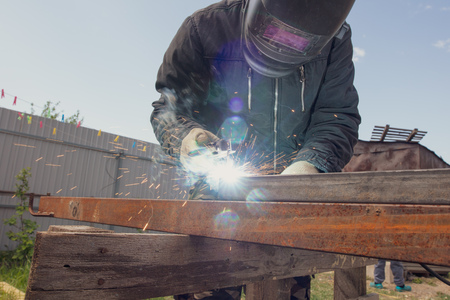 Welder welds metal at the construction site .の写真素材