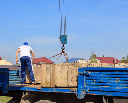 The crane loads old concrete blocks at the construction site .の写真素材