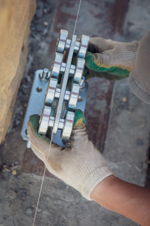 The worker installs rollers on the sliding gate .の写真素材