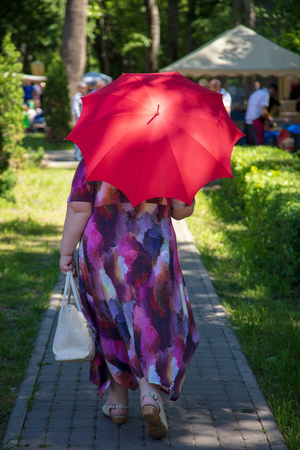 Woman with an umbrella in the park in summer .の写真素材