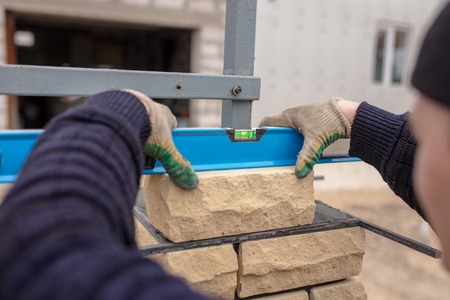 The man at the construction site is laying bricks .