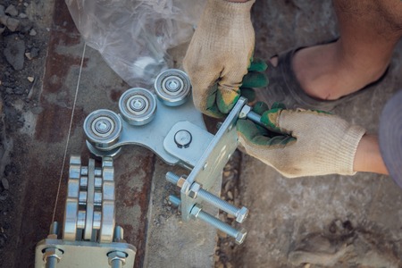 The worker installs rollers on the sliding gate .の写真素材