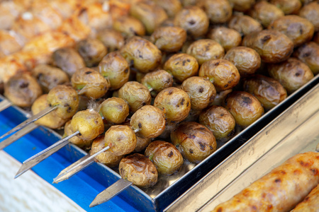 Shish kebab from fried potatoes on grill .