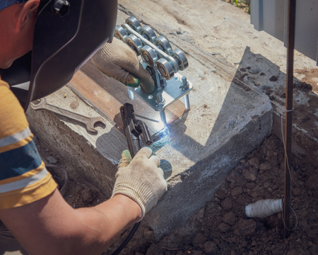The worker installs rollers on the sliding gate .