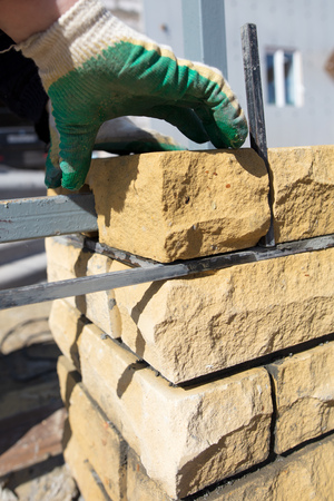 man builds a brick wall at a construction site .の写真素材