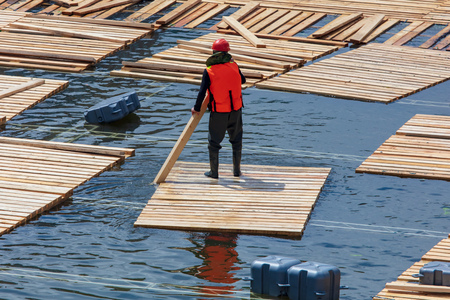Workers build a dam of wood on the river .