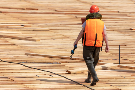 Workers build a dam of wood on the river .の写真素材