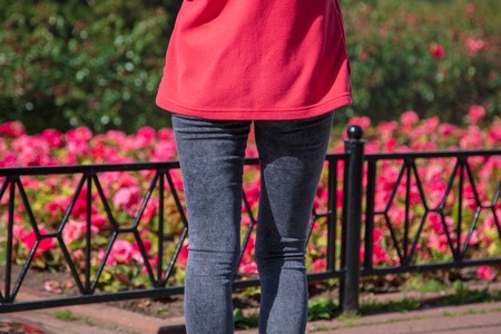 Legs of a girl in jeans in a park .