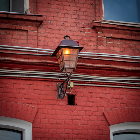 A street lamp burns on a brick house .の写真素材