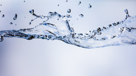 Splashing water with drops on the sky background .の写真素材
