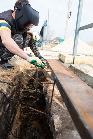Worker welds metal at the construction site .