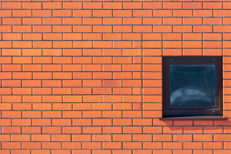 Window in the wall of red brick .