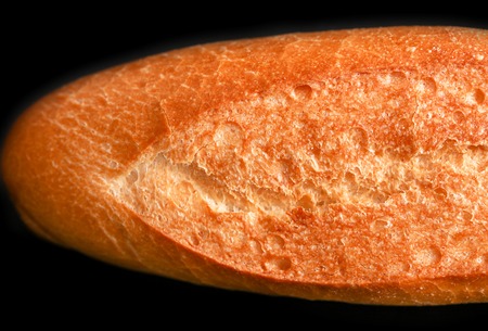 Fresh wheat bread on a black background .