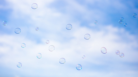 Soap bubbles in flight against the blue sky .の写真素材