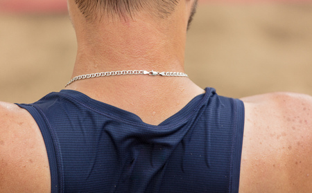 Silver chain around the neck of a strong man .