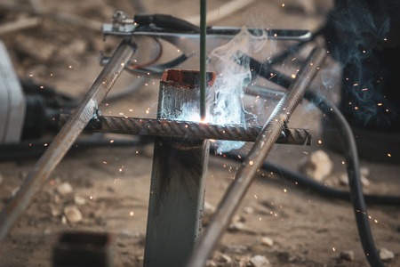 Worker welds metal at the construction site .