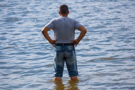 Guy in shorts in the water on the beach .の写真素材
