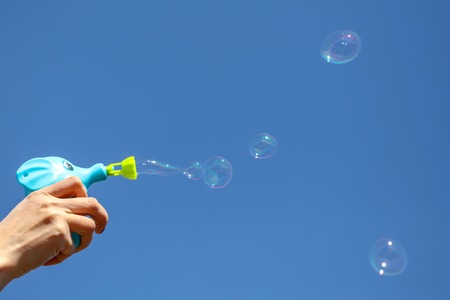 Hand with soap bubbles against the blue sky .の写真素材