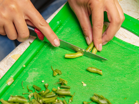 Chef slices green beans on a blackboard .