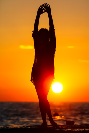 Silhouette of a girl at sunset on the sea .の写真素材