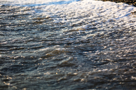 Waves at sea in the rays of sunset.