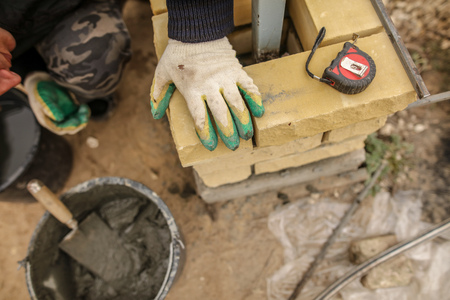 The worker is laying bricks on the fence .の写真素材