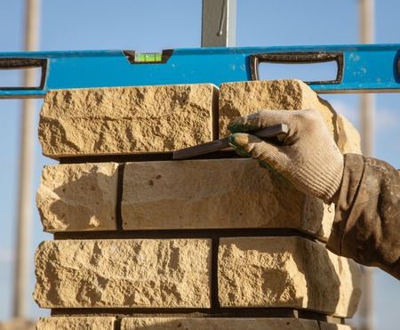 The worker is laying bricks on the fence .の写真素材