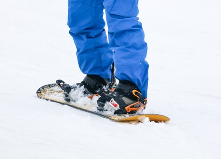 A guy is riding a snowboard from a mountain in winter .の写真素材