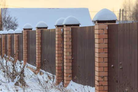 Snow on the fence of a country house in winter .の写真素材