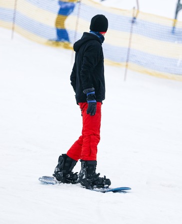 A guy is riding a snowboard from a mountain in winter .の写真素材