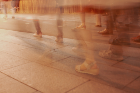 Legs of people in motion on the road as a background .