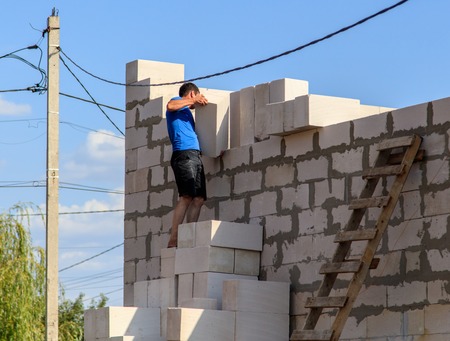 Worker lays bricks at a house construction .の写真素材